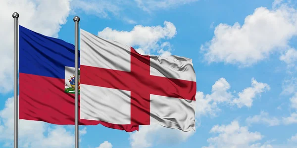 Haiti and England flag waving in the wind against white cloudy blue sky together. Diplomacy concept, international relations. — Stock Photo, Image