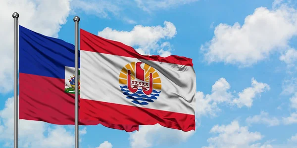 Гаїті і Французької Полінезії прапор розмахуючи в вітру проти білого хмарного синього неба разом. Концепція дипломатії, міжнародні відносини. — стокове фото