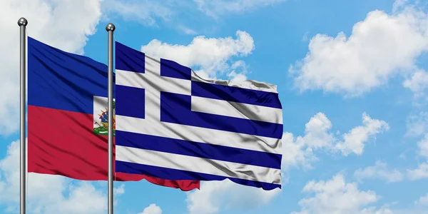 海地和希腊国旗在风中飘扬，白云蓝天相拥。外交概念、国际关系. — 图库照片