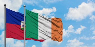 Haiti ve İrlanda bayrağı birlikte beyaz bulutlu mavi gökyüzüne karşı rüzgarda sallayarak. Diplomasi kavramı, uluslararası ilişkiler.