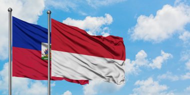 Haiti ve Monako bayrağı birlikte beyaz bulutlu mavi gökyüzüne karşı rüzgarda sallayarak. Diplomasi kavramı, uluslararası ilişkiler.