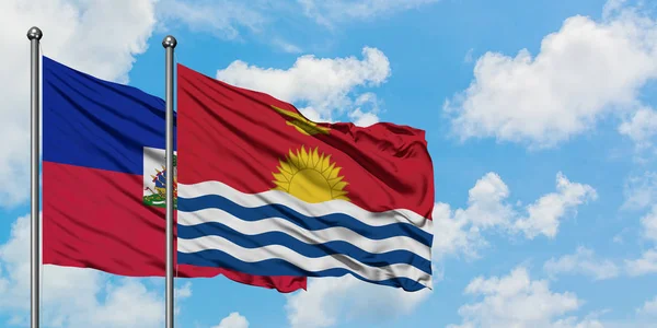 Bandera de Haití y Kiribati ondeando en el viento contra el cielo azul nublado blanco juntos. Concepto diplomático, relaciones internacionales . — Foto de Stock