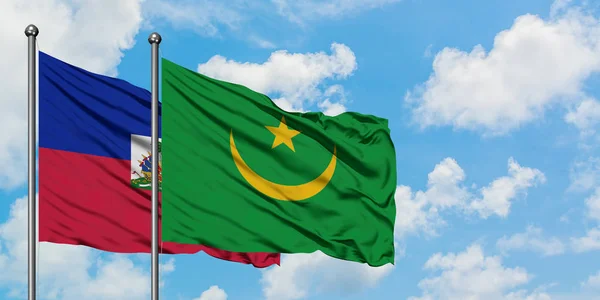 Bandera de Haití y Mauritania ondeando en el viento contra el cielo azul nublado blanco juntos. Concepto diplomático, relaciones internacionales . — Foto de Stock