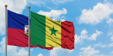 Haiti ve Senegal bayrağı birlikte beyaz bulutlu mavi gökyüzüne karşı rüzgarda sallayarak. Diplomasi kavramı, uluslararası ilişkiler.