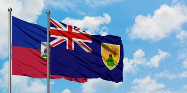 Haiti ve Turks ve Caicos Adaları bayrağı birlikte beyaz bulutlu mavi gökyüzüne karşı rüzgarda sallayarak. Diplomasi kavramı, uluslararası ilişkiler.