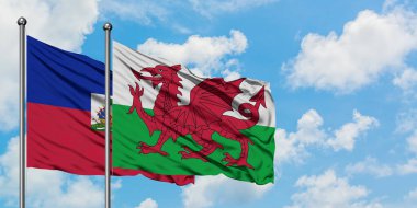 Haiti ve Galler bayrağı birlikte beyaz bulutlu mavi gökyüzüne karşı rüzgarda sallayarak. Diplomasi kavramı, uluslararası ilişkiler.