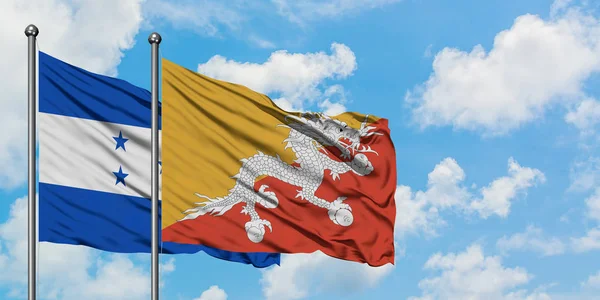 온두라스와 부탄 국기가 함께 하얀 흐린 푸른 하늘에 바람을 흔들고. 외교 개념, 국제 관계. — 스톡 사진