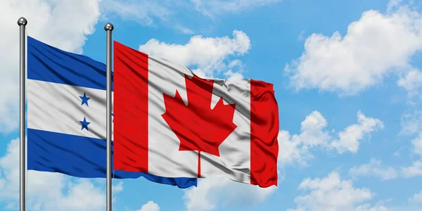 Bandera de Honduras y Canadá ondeando en el viento contra el cielo azul nublado blanco juntos. Concepto diplomático, relaciones internacionales . — Foto de Stock