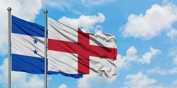 Honduras und england flagge wehen gemeinsam im wind vor weißem wolkenblauem himmel. Diplomatie-Konzept, internationale Beziehungen. — Stockfoto