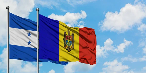 Honduras en Moldavië vlag zwaaien in de wind tegen witte bewolkte blauwe hemel samen. Diplomatie concept, internationale betrekkingen. — Stockfoto