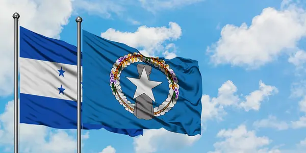 Honduras ve Kuzey Mariana Adaları bayrağı birlikte beyaz bulutlu mavi gökyüzüne karşı rüzgarda sallayarak. Diplomasi kavramı, uluslararası ilişkiler. — Stok fotoğraf