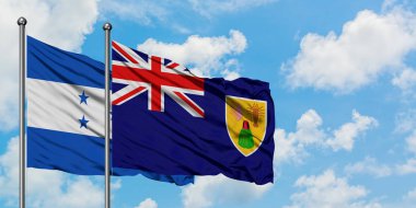 Honduras ve Turks ve Caicos Adaları bayrağı birlikte beyaz bulutlu mavi gökyüzüne karşı rüzgarsal sallayarak. Diplomasi kavramı, uluslararası ilişkiler.