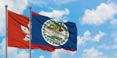 Hong Kong ve Belize bayrağı birlikte beyaz bulutlu mavi gökyüzüne karşı rüzgarda sallayarak. Diplomasi kavramı, uluslararası ilişkiler.