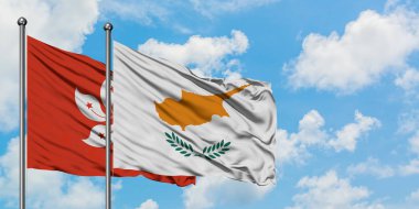 Hong Kong ve Kıbrıs bayrağı birlikte beyaz bulutlu mavi gökyüzüne karşı rüzgarda sallayarak. Diplomasi kavramı, uluslararası ilişkiler.