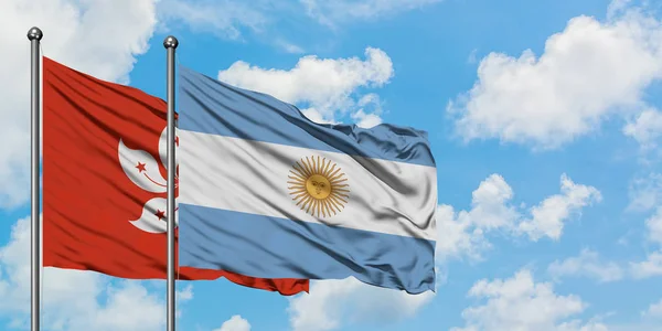 Bandera de Hong Kong y Argentina ondeando en el viento contra el cielo azul nublado blanco juntos. Concepto diplomático, relaciones internacionales . — Foto de Stock