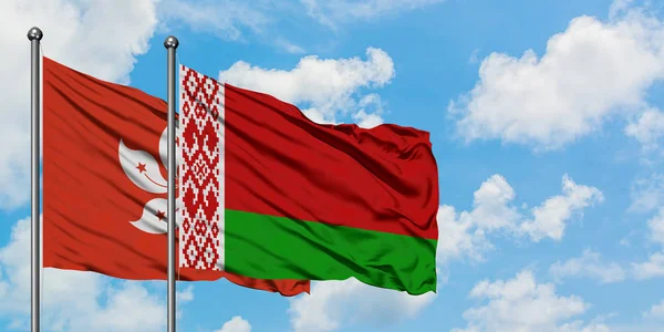 Bandera de Hong Kong y Bielorrusia ondeando en el viento contra el cielo azul nublado blanco juntos. Concepto diplomático, relaciones internacionales . — Foto de Stock