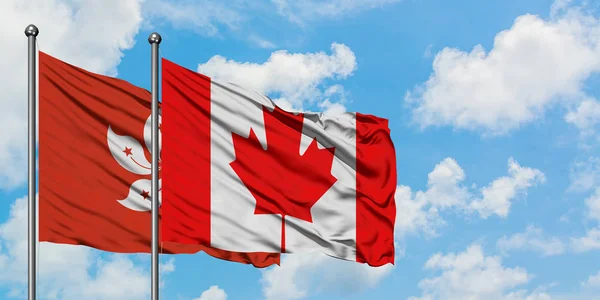 Bandera de Hong Kong y Canadá ondeando en el viento contra el cielo azul nublado blanco juntos. Concepto diplomático, relaciones internacionales . —  Fotos de Stock