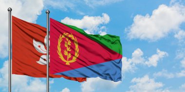 Hong Kong ve Eritre bayrağı birlikte beyaz bulutlu mavi gökyüzüne karşı rüzgarda sallayarak. Diplomasi kavramı, uluslararası ilişkiler.