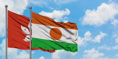 Hong Kong ve Nijer bayrağı birlikte beyaz bulutlu mavi gökyüzüne karşı rüzgarda sallayarak. Diplomasi kavramı, uluslararası ilişkiler.