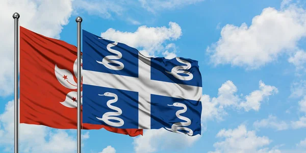 Bandera de Hong Kong y Martinica ondeando en el viento contra el cielo azul nublado blanco juntos. Concepto diplomático, relaciones internacionales . —  Fotos de Stock