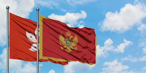 Bandeira de Hong Kong e Montenegro agitando no vento contra o céu azul nublado branco juntos. Conceito de diplomacia, relações internacionais . — Fotografia de Stock