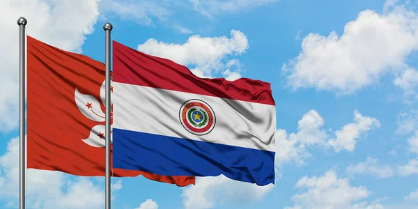 Hong Kong e Paraguay sventolano insieme la bandiera contro il bianco cielo blu nuvoloso. Concetto di diplomazia, relazioni internazionali . — Foto Stock