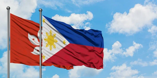 Bandeira de Hong Kong e Filipinas agitando no vento contra o céu azul nublado branco juntos. Conceito de diplomacia, relações internacionais . — Fotografia de Stock