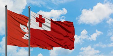 Hong Kong ve Tonga bayrağı birlikte beyaz bulutlu mavi gökyüzüne karşı rüzgarda sallayarak. Diplomasi kavramı, uluslararası ilişkiler.
