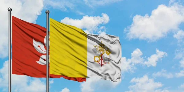 Bandera de Hong Kong y Ciudad del Vaticano ondeando en el viento contra el cielo azul nublado blanco juntos. Concepto diplomático, relaciones internacionales . — Foto de Stock