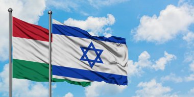 Macaristan ve İsrail bayrağı birlikte beyaz bulutlu mavi gökyüzüne karşı rüzgarda sallayarak. Diplomasi kavramı, uluslararası ilişkiler.