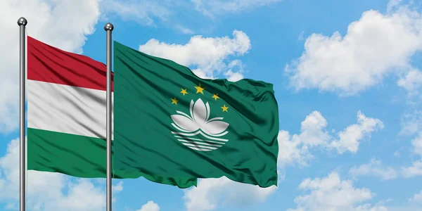 Hungary and Macao flag waving in the wind against white cloudy blue sky together. Diplomacy concept, international relations.