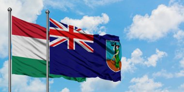 Macaristan ve Montserrat bayrağı birlikte beyaz bulutlu mavi gökyüzüne karşı rüzgarda sallayarak. Diplomasi kavramı, uluslararası ilişkiler.