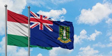 Macaristan ve İngiliz Virgin Adaları bayrağı birlikte beyaz bulutlu mavi gökyüzüne karşı rüzgarda sallayarak. Diplomasi kavramı, uluslararası ilişkiler.