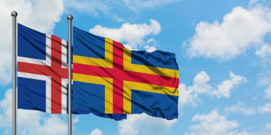 İzlanda ve Aland Adaları bayrağı birlikte beyaz bulutlu mavi gökyüzüne karşı rüzgarsal sallayarak. Diplomasi kavramı, uluslararası ilişkiler.