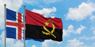 İzlanda ve Angola bayrağı birlikte beyaz bulutlu mavi gökyüzüne karşı rüzgarda sallayarak. Diplomasi kavramı, uluslararası ilişkiler.
