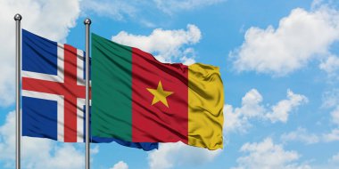 İzlanda ve Kamerun bayrağı birlikte beyaz bulutlu mavi gökyüzüne karşı rüzgarsal sallayarak. Diplomasi kavramı, uluslararası ilişkiler.