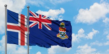 İzlanda ve Cayman Adaları bayrağı birlikte beyaz bulutlu mavi gökyüzüne karşı rüzgarsal sallayarak. Diplomasi kavramı, uluslararası ilişkiler.