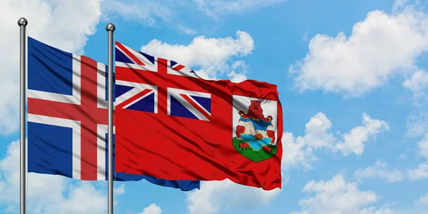 IJsland en Bermuda vlag zwaaien in de wind tegen witte bewolkte blauwe hemel samen. Diplomatie concept, internationale betrekkingen. — Stockfoto