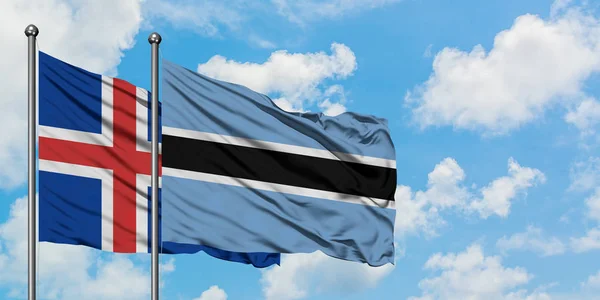 Islanda e Botswana sventolano nel vento contro il bianco cielo blu nuvoloso insieme. Concetto di diplomazia, relazioni internazionali . — Foto Stock