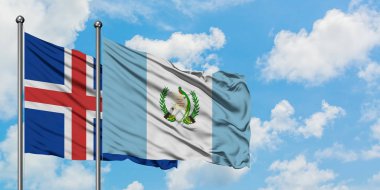İzlanda ve Guatemala bayrağı birlikte beyaz bulutlu mavi gökyüzüne karşı rüzgarsal sallayarak. Diplomasi kavramı, uluslararası ilişkiler.