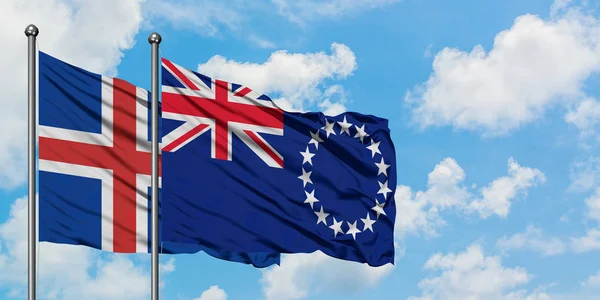 Bandera de Islandia y las Islas Cook ondeando en el viento contra el cielo azul nublado blanco juntos. Concepto diplomático, relaciones internacionales . — Foto de Stock