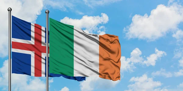 Islanda e Irlanda sventolano nel vento contro il bianco cielo blu nuvoloso insieme. Concetto di diplomazia, relazioni internazionali . — Foto Stock