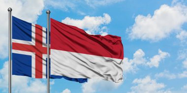 İzlanda ve Monako bayrağı birlikte beyaz bulutlu mavi gökyüzüne karşı rüzgarsal sallayarak. Diplomasi kavramı, uluslararası ilişkiler.