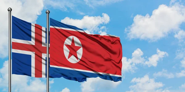 Iceland and North Korea flag waving in the wind against white cloudy blue sky together. Diplomacy concept, international relations. — Stock Photo, Image