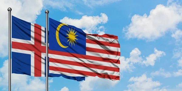 Ісландія і Малайзія прапор розмахуючи в вітру проти білого хмарного синього неба разом. Концепція дипломатії, міжнародні відносини. — стокове фото