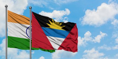 Hindistan ve Antigua ve Barbuda bayrağı birlikte beyaz bulutlu mavi gökyüzüne karşı rüzgarda sallayarak. Diplomasi kavramı, uluslararası ilişkiler.