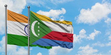 Hindistan ve Komorbayrağı birlikte beyaz bulutlu mavi gökyüzüne karşı rüzgarda sallayarak. Diplomasi kavramı, uluslararası ilişkiler.