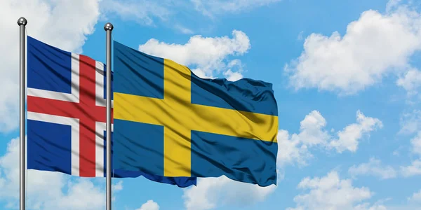 Bandera de Islandia y Suecia ondeando en el viento contra el cielo azul nublado blanco juntos. Concepto diplomático, relaciones internacionales . — Foto de Stock