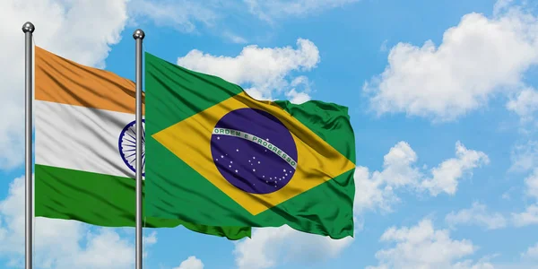 India and Brazil flag waving in the wind against white cloudy blue sky together. Diplomacy concept, international relations.