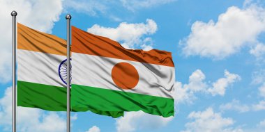 Hindistan ve Nijer bayrağı birlikte beyaz bulutlu mavi gökyüzüne karşı rüzgarda sallayarak. Diplomasi kavramı, uluslararası ilişkiler.